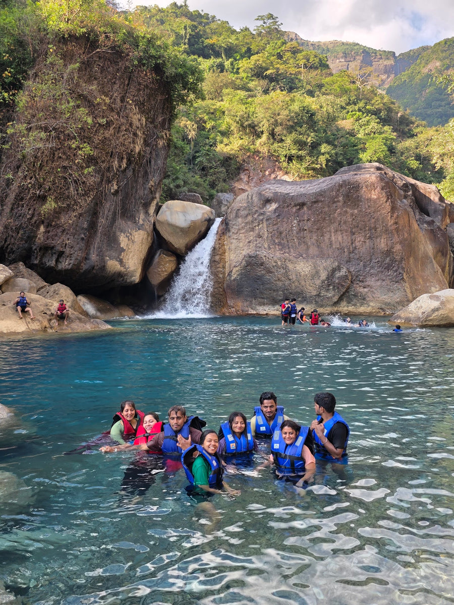 A group in life jackets floating together in a blue pool