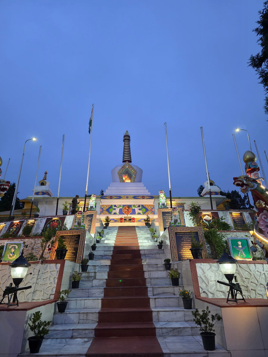 A war memorial stupa lit up at dusk