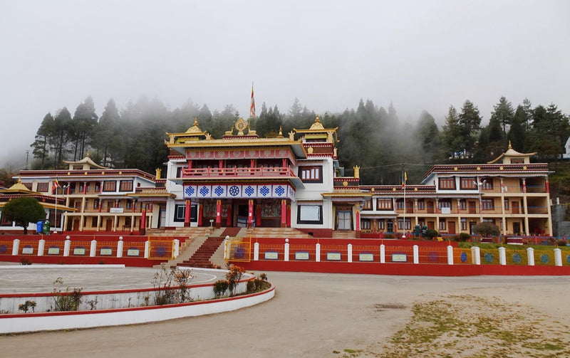 A red and gold Tibetan Buddhist monastery in mist at Bomdila