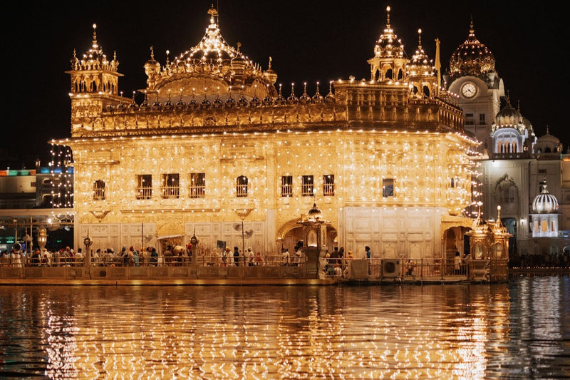 The Golden Temple in Amritsar lit up at night and reflected in the water of its pool